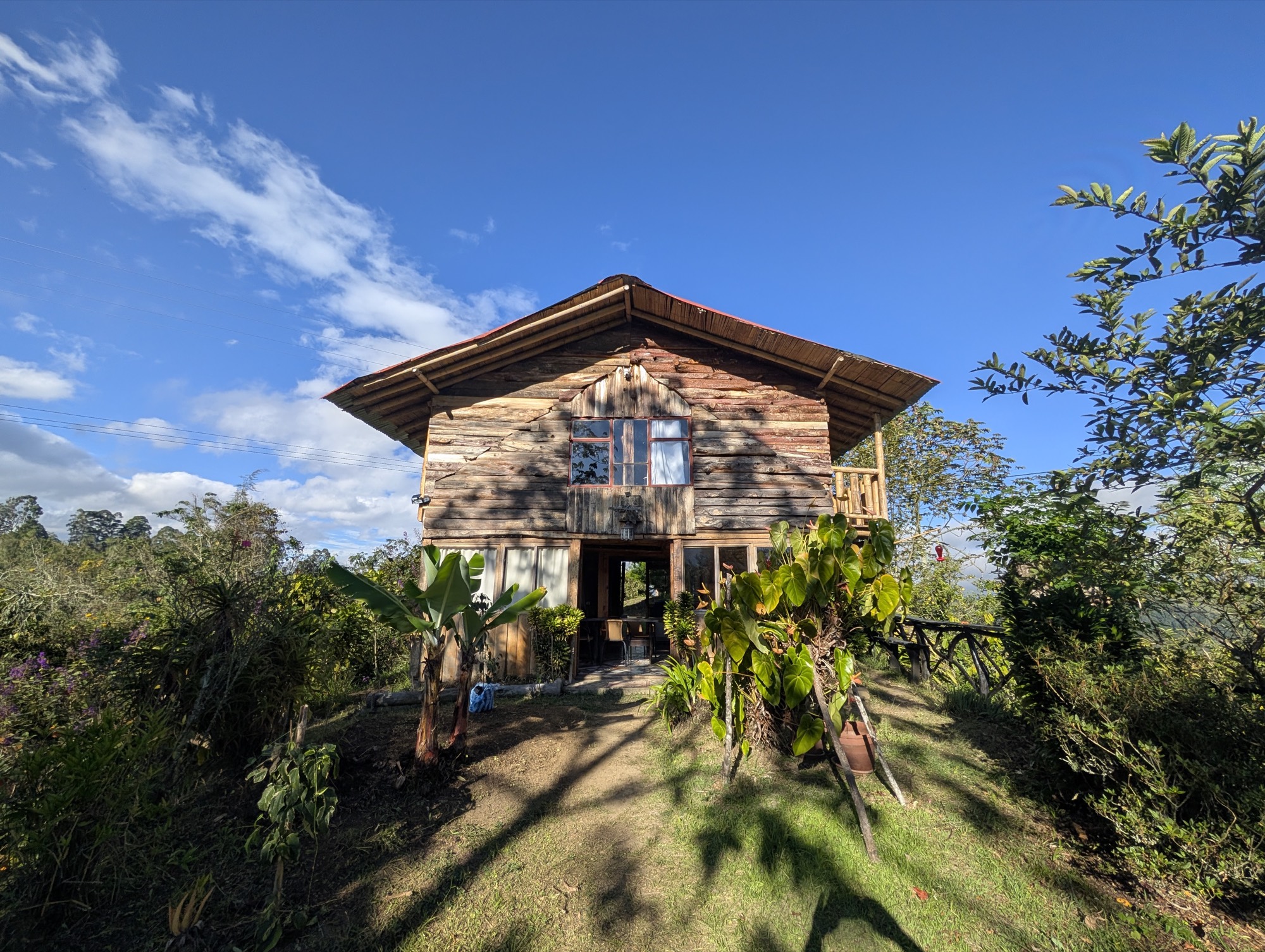 La cabaña de madera sobre la montaña, con la cordillera al fondo